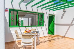 a dining room with a table and chairs and a mirror at Bungalow Alma Ocean View in Puerto del Carmen