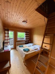 ein Schlafzimmer mit einem Etagenbett und einer Leiter in der Unterkunft Hotel Pod Sokolím in Terchová