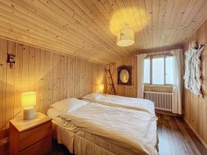 een slaapkamer met een groot bed en een raam bij Fouquet Apartments in Verbier
