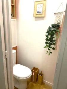 a bathroom with a toilet and a plant on the wall at Appartement spacieux à Cergy in Pontoise