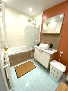 a bathroom with a sink and a tub and a toilet at Appartement spacieux à Cergy in Pontoise