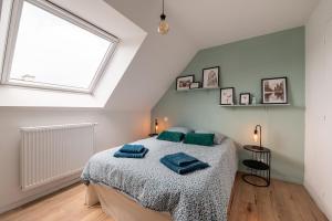um quarto com uma cama e uma grande janela em Villa West Attitude em Erdeven