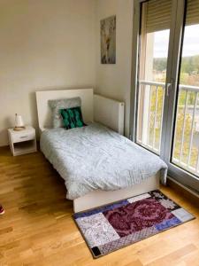 1 dormitorio con cama y ventana grande en Appartement spacieux à Cergy, en Pontoise