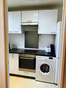 a kitchen with a washing machine and a washer at Appartement spacieux à Cergy in Pontoise