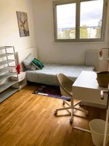 Zimmer mit einem Bett, einem Schreibtisch und einem Fenster in der Unterkunft Appartement spacieux à Cergy in Pontoise
