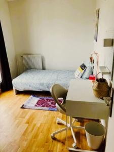 1 dormitorio con cama, escritorio y silla en Appartement spacieux à Cergy, en Pontoise