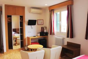 Hotel Amic Colon في بالما دي ميورقة: غرفة مع طاولة وكراسي ونافذة