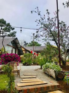 a garden with a bench and some flowers at Đồi Gió Hú Homestay & Coffee - Măng Đen in Kon Tum