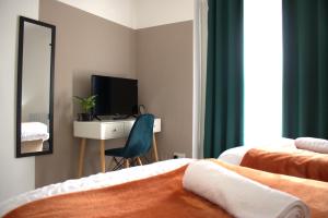 a bedroom with two beds and a desk and a mirror at Top Spot 2-Bed Spacious Apartment Town Centre Train Station WIFI in Colchester