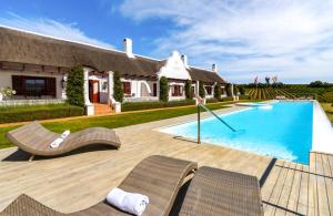 eine Villa mit einem Pool vor einem Haus in der Unterkunft Aaldering Luxury Lodges in Stellenbosch