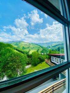 una ventana con vistas a las montañas desde una casa en Hotel Pod Sokolím, en Terchová