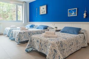 two beds in a room with blue walls at Casa Majestic in Cunit +54 photos