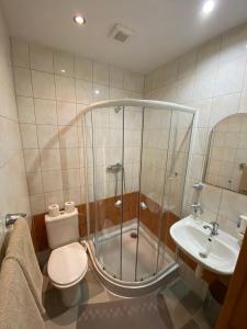 a bathroom with a shower and a toilet and a sink at Hotel Pod Sokolím in Terchová