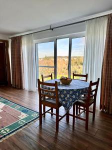 a dining room with a table and chairs and windows at Casa Flammini Guesthouse in Alvaiázere