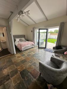 Dwylig Isa Holiday Cottages في Rhuddlan: غرفة نوم بسرير واريكة وكرسي