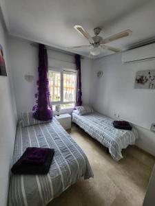 1 dormitorio con 2 camas y ventilador de techo en FABULOUS 2 BED 2 BATH APARTMENT ! en Villamartín