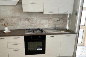 a kitchen with a stove and a sink at Vento Di Mare in Torre Lapillo