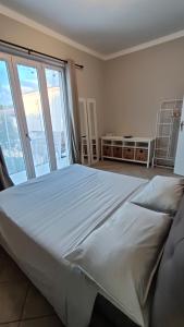 a large bed in a room with a large window at Appartamento vicino al mare in Forte dei Marmi