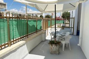 a table and chairs on a balcony with an umbrella at Vento Di Mare in Torre Lapillo