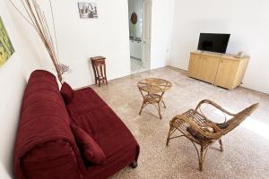 a living room with a red couch and a table at Vento Di Mare in Torre Lapillo