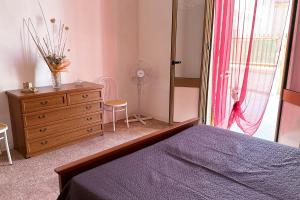 a bedroom with a bed and a dresser and a window at Vento Di Mare in Torre Lapillo