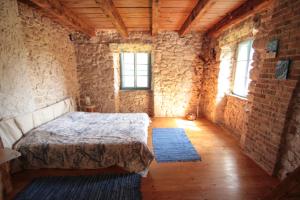 a bedroom with a bed and a brick wall at Holiday Home Botanica in Drenje