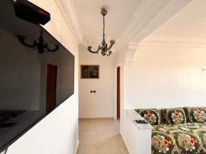 een woonkamer met een bank en een tv bij Casablanca Beautiful and Tranquil Family Apartment in Casablanca