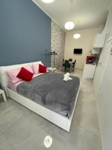 una camera da letto con un letto con cuscini rossi e rosa di Margò Luxury a Mola di Bari