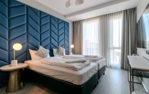 een slaapkamer met een groot bed met een blauwe muur bij Midtown Hotel in Reykjavík
