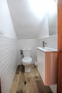 Baño blanco con aseo y lavamanos en Casa Sabelín en Suesa