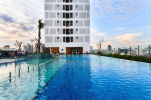 een zwembad voor een hoog gebouw bij Kandy in Rivergate Luxury Apartment - near Ben Thanh market in Ho Chi Minh-stad