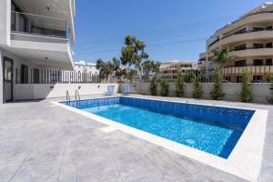 a swimming pool in front of a building at Maryam's 2-BR Apt Facing Larnaca Harbor W/ Pool in Larnaka
