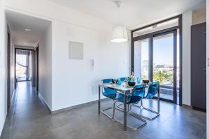a dining room with a table and blue chairs at Maryam's 2-BR Apt Facing Larnaca Harbor W/ Pool in Larnaka
