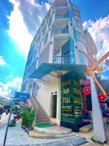 wysoki budynek z znakiem przed nim w obiekcie Thái Thịnh Hotel w mieście Dồng Văn