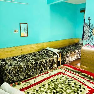 a room with two beds and a rug on the floor at Madana Inn Manali in Manāli