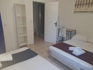 a bedroom with two beds and a desk with towels at Hotel Du Centre in Marseille