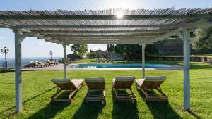un pergolato con sedie e una piscina di Torre Ginestre 12, Emma Villas ad Arezzo