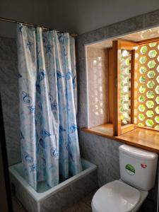 uma casa de banho com um WC e uma cortina de chuveiro em Rassom Hostel em Samarkand