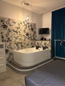 un bagno con una grande vasca e una tenda blu di Casa Vacanze Happy Moment a Catania