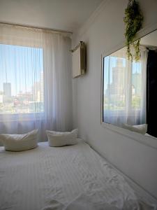 um quarto branco com uma grande janela e uma cama em Marszałkowska Apartments Studio Central Warsaw em Varsóvia