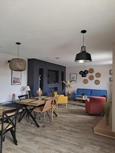 a living room with a table and chairs and a couch at La Flânerie in Widehem