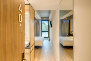 a room with a mirror and a bed and a bathroom at B&B HOTEL Guimarães in Guimarães