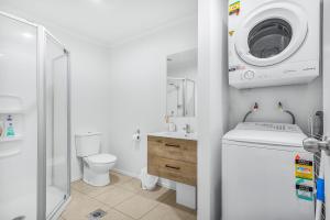 a bathroom with a washing machine and a washer at Park view, Proximity, Value in Hamilton