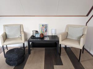 2 sillas y una mesa en una habitación en Hotel De Gravin van Vorden en Vorden