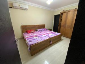 a bedroom with a bed with a purple comforter at Laserina Palm Beach for families only ground floor with big garden in Ain Sokhna +9 photos