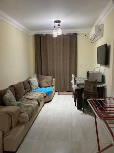 un salon avec un canapé et une table dans l'établissement Laserina Palm Beach for families only with ground floor with big garden there is entrance extra fees 250 LE per adult, à Ain Sokhna