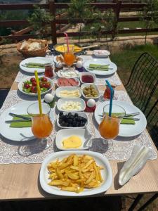 - une table avec des assiettes de nourriture et de boissons dans l'établissement Of Çamlık bungalov, à Of