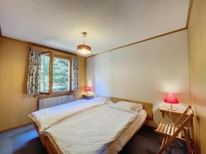 a bedroom with a bed and two lamps and a window at pâquerette rez in Verbier