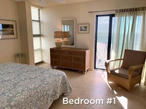 a bedroom with a bed and a chair and a window at Outstanding Oceanfront Oasis Directly on Beach #8 in Marathon +15 photos