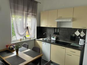 a kitchen with a table and a sink and a window at Apartman Laura in Dramalj
